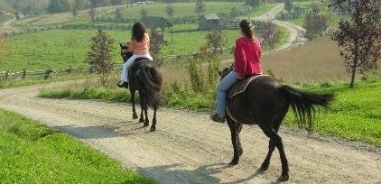 Deux femmes chevauchant des chevaux sur une route en terre